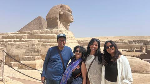       Family posing in front of the Great Sphinx with the Pyramid of Khafre behind
  