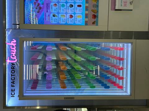       Colorful display of popsicles inside a vertical freezer vending machine
  