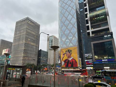       Urban streetscape of Gangnam with modern high-rise buildings and large billboard of a footballer
  