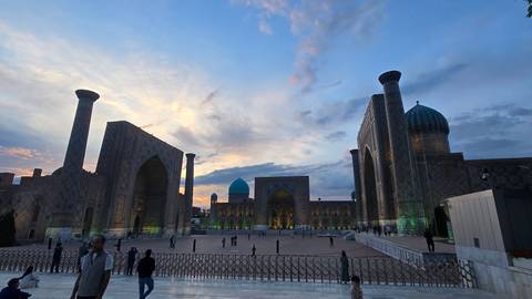       Evening light glows over Samarkand’s Registan square with its majestic blue domes and soaring portals.
  