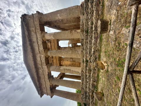       Ancient Greek temple ruins with massive Doric columns under a partly cloudy sky.
  