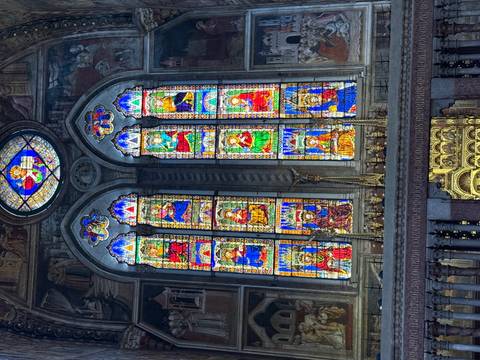       Vibrant stained-glass windows inside an ornate Italian cathedral.
  