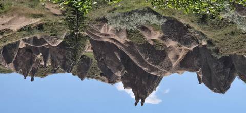       Jagged volcanic rock formations of Devrent Valley under a bright blue sky.
  