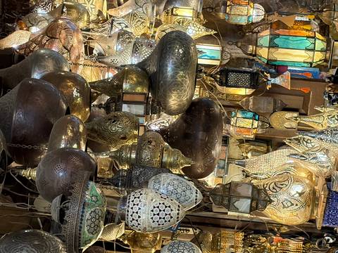       Colorful brass and glass lanterns hang densely in a traditional Egyptian market stall.
  