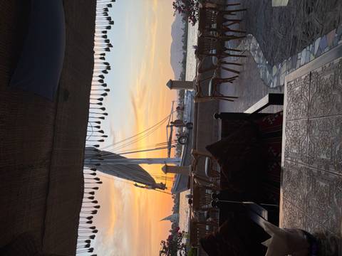       Traditional sailboat moored on the Nile at sunset viewed from a riverside café.
  