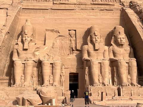       Colossal seated statues carved into the sandstone façade of Abu Simbel temple.
  