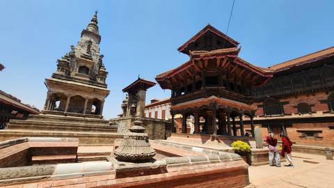       Historic brick temples and stone structures in a sunny courtyarded square
  