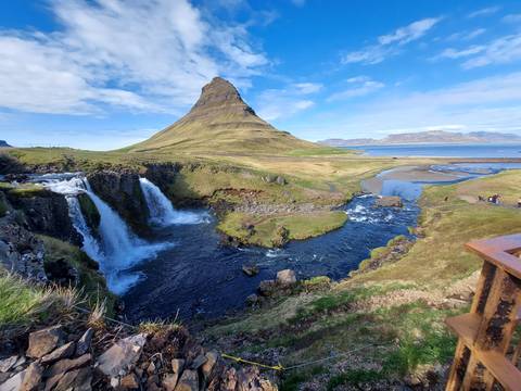       Picturesque Kirkjufell mountain with twin waterfalls cascading into a blue river.
  