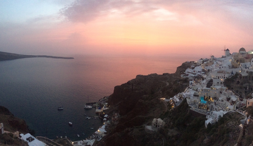       Coastal town on a hill during a stunning sunset.
  