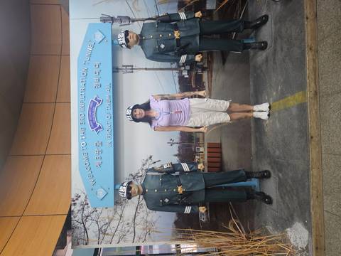       A visitor stands between two uniformed soldier mannequins at the DMZ display for the 3rd Infiltration Tunnel.
  
