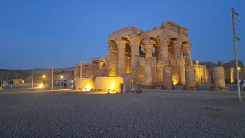       Evening blue-hour shot of Kom Ombo Temple lit by spotlights against a fading sky.
  