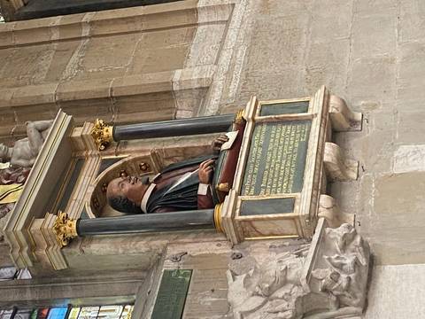       Bust monument of William Shakespeare inside a stone church alcove.
  