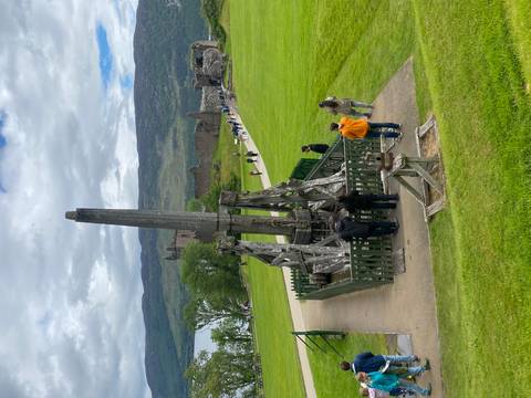       Wooden medieval trebuchet on the grounds overlooking ruins by a Scottish loch.
  