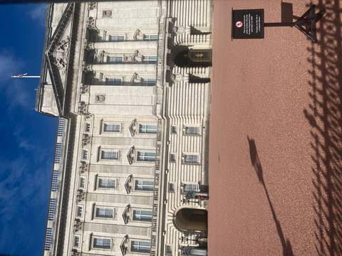       Front facade of Buckingham Palace seen across the forecourt on a sunny day.
  