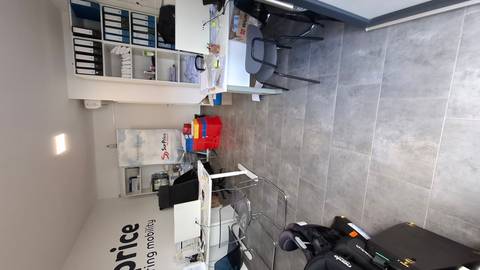       Small office interior with desks, chairs, filing shelves and car-rental signage.
  