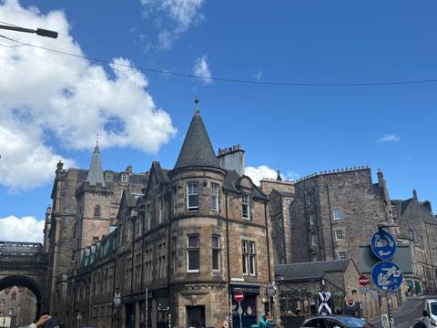      Stone and brick Victorian buildings of Edinburgh’s Old Town beneath a bright blue sky.
  