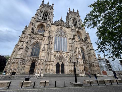       Grand Gothic façade of York Minster with soaring spires and elaborate stonework.
  