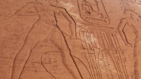      Close-up of ancient Egyptian hieroglyphic relief carving etched into sandstone.
  
