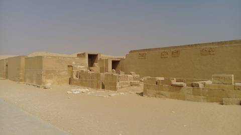       Ancient sandstone ruins in a desert landscape under a hazy sky
  