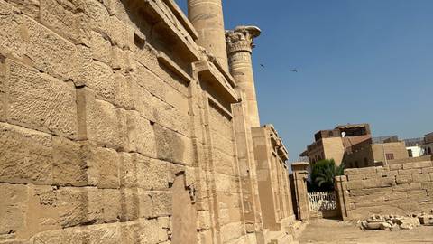       Close view of sandstone temple walls and columns under a clear blue sky
  