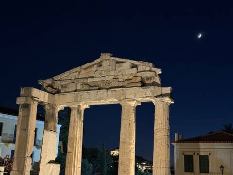       Illuminated ancient marble gateway with crescent moon in the night sky
  