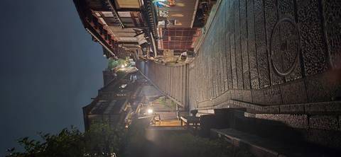       Atmospheric night view of Kyoto’s historic stone-paved Ninenzaka slope lined with wooden machiya houses.
  