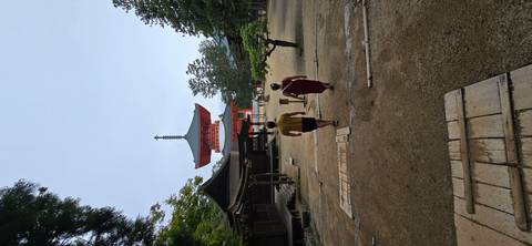       Two travelers walking toward a towering orange pagoda within a temple complex
  