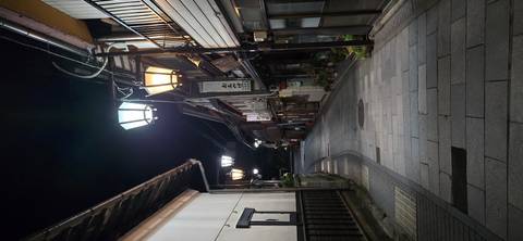       Quiet narrow street of traditional buildings lit by warm lanterns at night
  