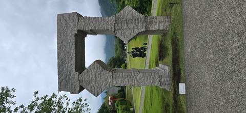       Granite arch sculpture overlooking manicured lawns and misty hills in outdoor museum
  