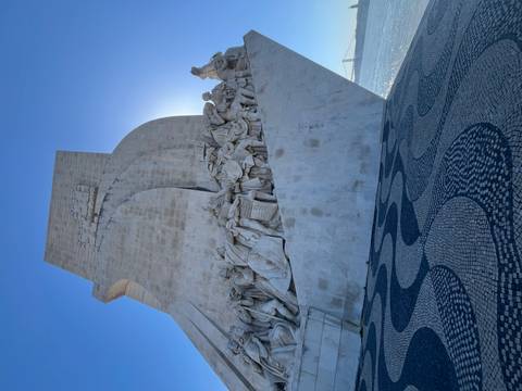       Huge sculpted stone monument of explorers beside the Tagus river with patterned mosaic plaza in front
  