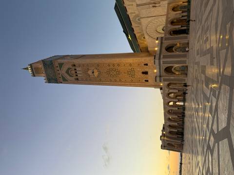       Majestic Hassan II Mosque minaret rises above expansive marble plaza at dusk in Casablanca
  