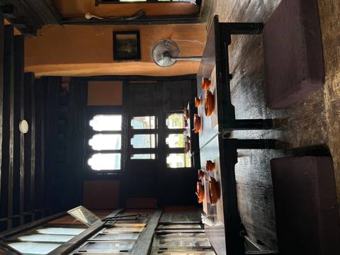       Traditional low Bhutanese dining room with wooden tables set with ceramic bowls near a window
  