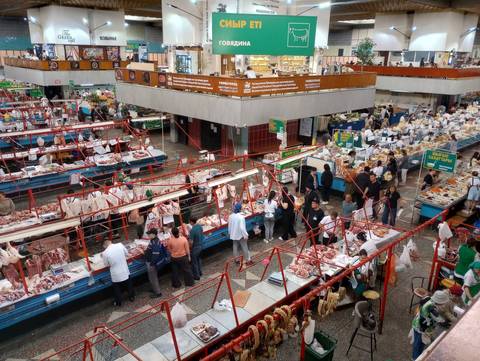       Bustling indoor meat market with numerous vendors and shoppers in Central Asia
  