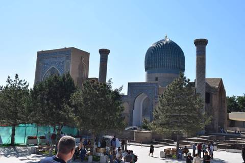       Samarkand's Gur-e Amir mausoleum complex with blue-tiled dome and minarets on sunny day
  