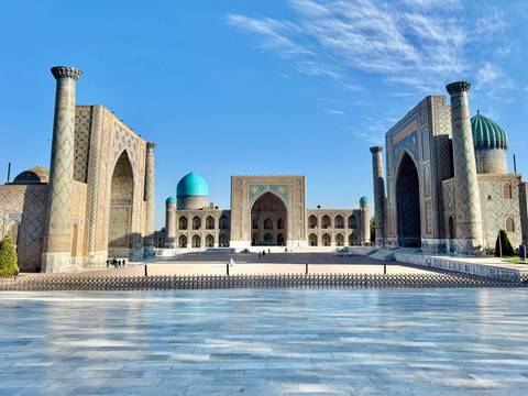       Daytime panorama of the three madrasahs of Registan against clear blue sky
  