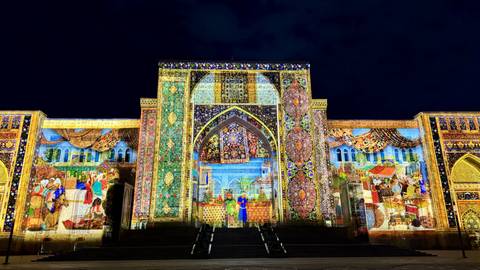       Nighttime projection mapping show on richly tiled façade of historic building
  