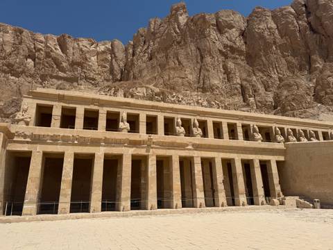       Colonnaded terraces of the Mortuary Temple of Hatshepsut set against sheer desert cliffs.
  