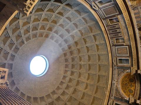       Interior of Rome's Pantheon dome with oculus beam illuminating patterned ceiling
  