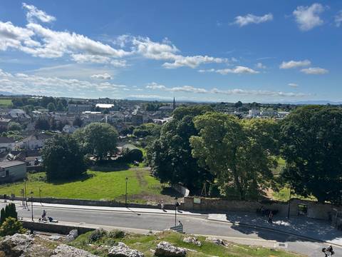       Elevated view over a small Irish town with church spires, trees and rolling countryside
  