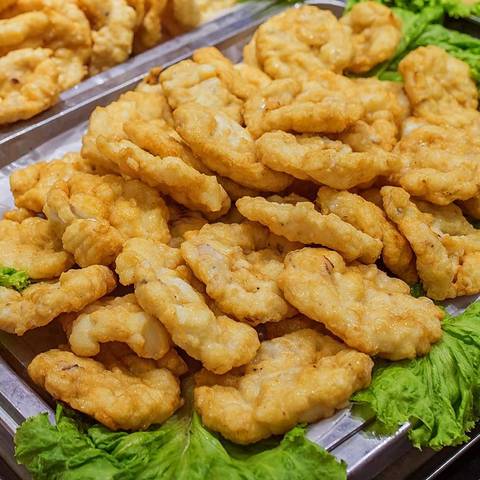       Tray piled high with golden fried fish cakes or fritters
  
