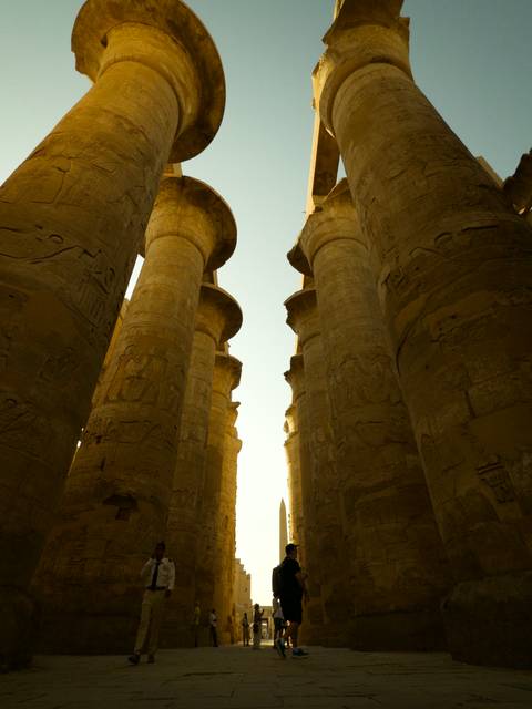       Sunlight filtering between towering carved columns at Karnak Temple
  