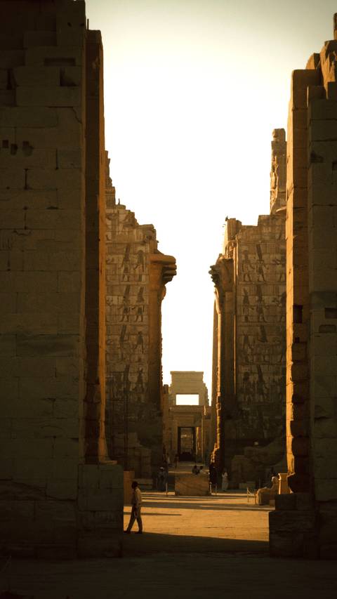       Temple corridor silhouette view through aligned stone gateways at Karnak
  