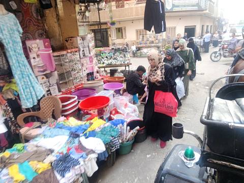       Bustling local street market in Cairo with shoppers browsing household goods
  