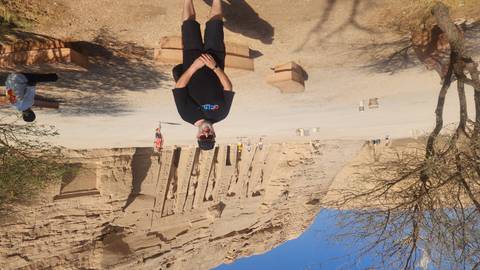       Traveler standing before the smaller rock-cut temple at Abu Simbel on a bright day
  
