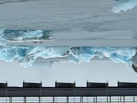       Blue icebergs floating beneath a bridge in the misty Jokulsarlon glacial lagoon
  
