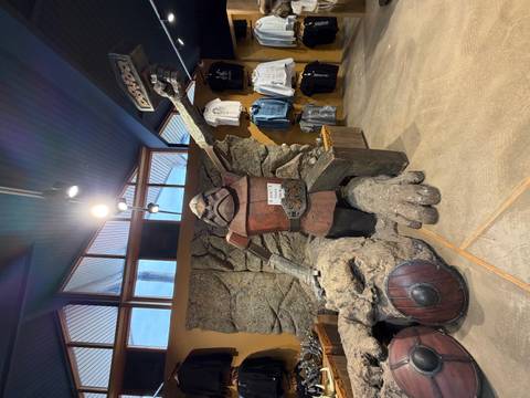       Indoor shop display featuring a large troll statue with shields and Icelandic themed souvenirs
  