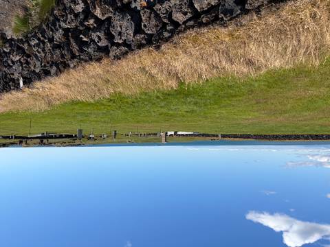       Sparse cliff-edge cemetery with scattered headstones overlooking the ocean on a clear day
  