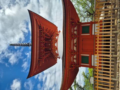       Brightly painted multi-tier pagoda set against a blue sky with scattered clouds.
  