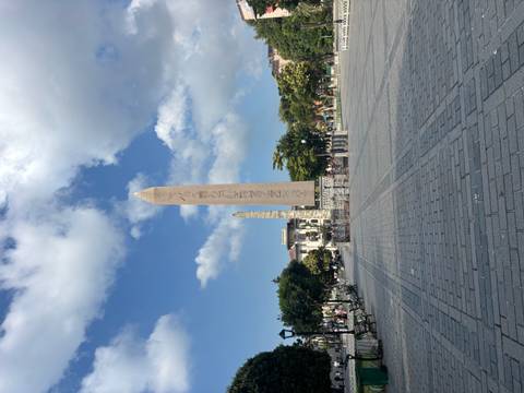       The ancient Egyptian Obelisk of Theodosius towers above an open plaza under scattered clouds.
  