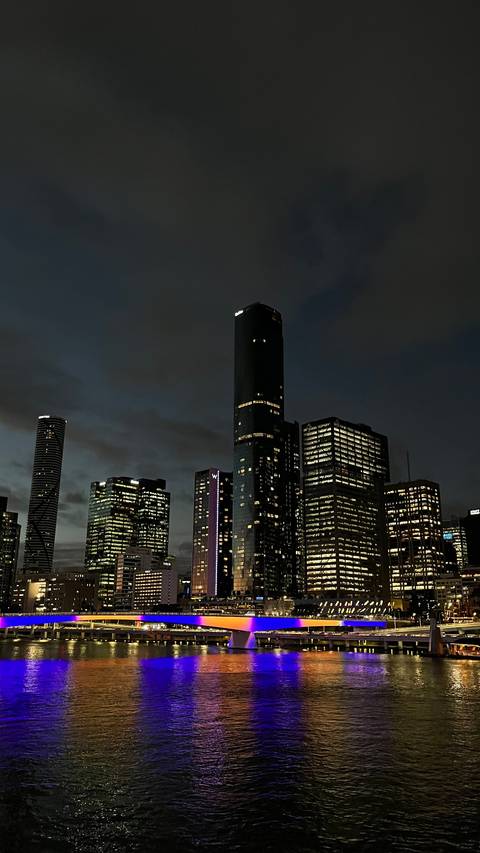       City skyline of modern high-rise towers illuminated against a dark evening sky
  
